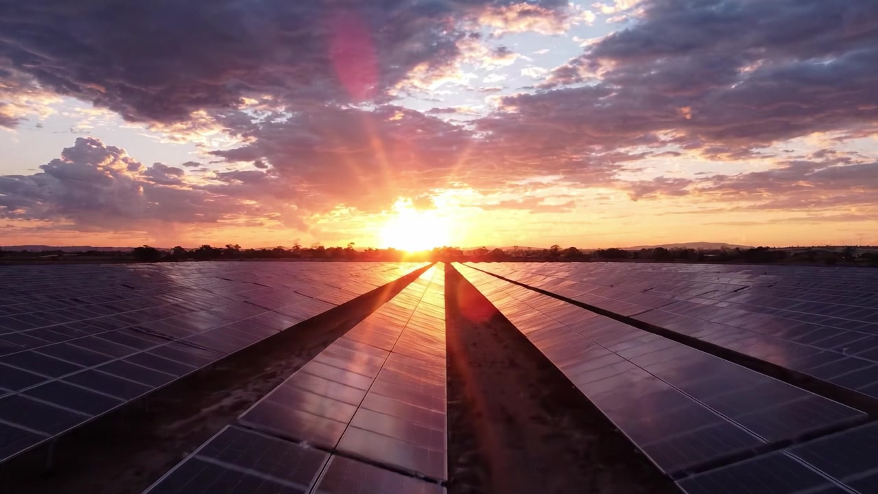 Betagende solnedgang over solpaneler: Et imponerende syn på vedvarende energis indvirkning på landskabet i et smukt aftenlys.