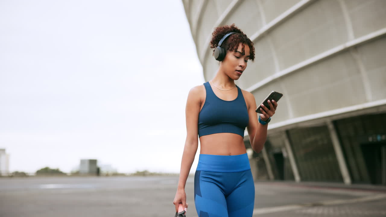mujer haciendo ejercicio al aire libre con auriculares y teléfono
