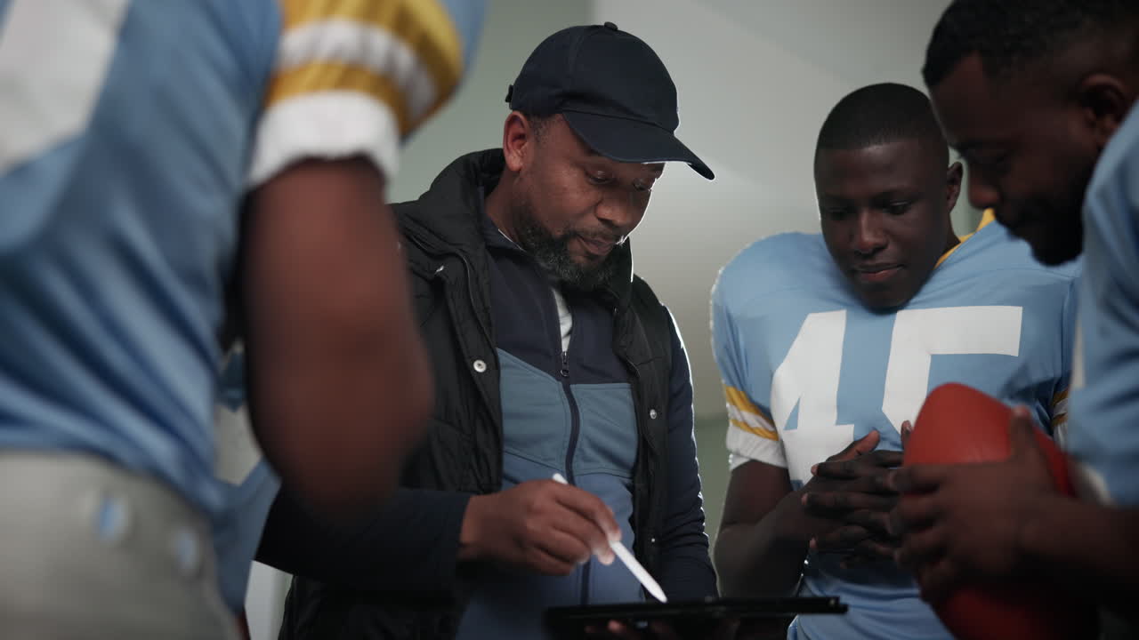 Football Coach Discussing Strategy with Team