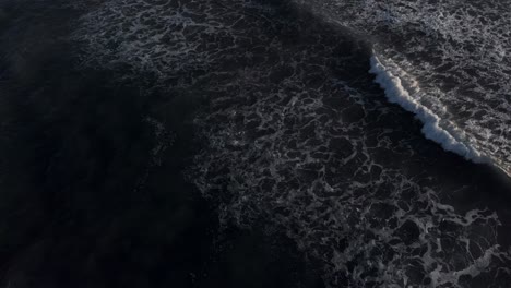 the beautiful white waves of costa rica rolling towards the rocky beach - aerial