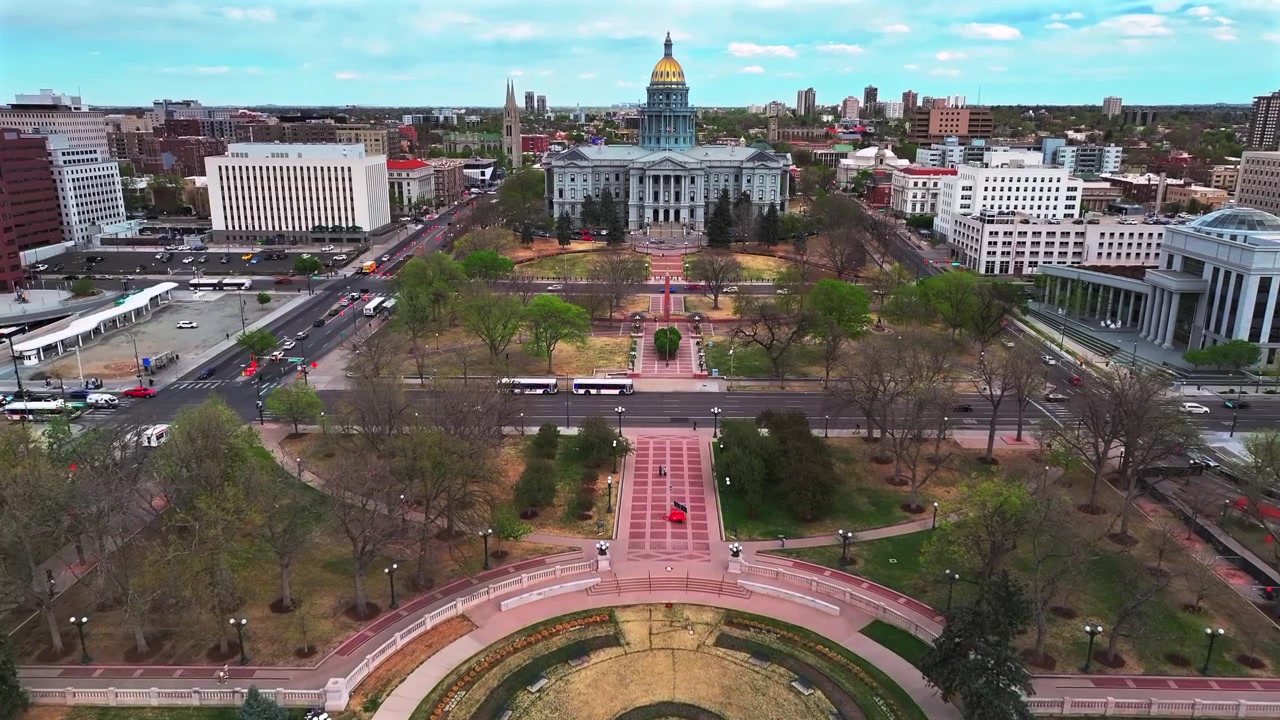 Downtown Denver Capitol Hill Civic Center Park E Coflax Avenue biltrafik bygade forår overskyet eftermiddag Colorado Capitol Civic bygning luftdrone gyldne kuppelbygninger fremadgående panoreringsbevægelse opad.