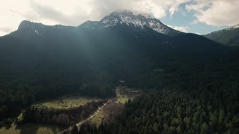 Heaven-Sky,-Mountain-Peaks-and-Pine-Forest-with-Sunlight-Rays,-Aerial-Shot-of-Lake-Doxa-Greece,-Idyllic-Godlike-Travel-Destination,-Ziria-and-Chelmos