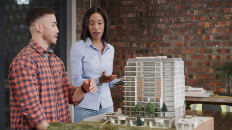 Diverse-male-and-female-architect-discussing-architectural-model,-slow-motion