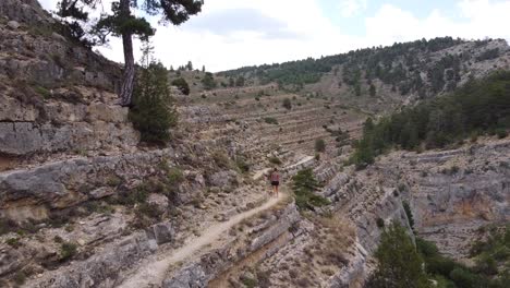 Ruta-Del-Barranco-De-La-Hoz-In-Calomarde,-Teruel,-Guadalajara,-Spanien---Luftdrohnenansicht-Eines-Touristischen-Mädchens,-Das-Die-Schöne-Wanderung-Durch-Die-Schlucht-Geht