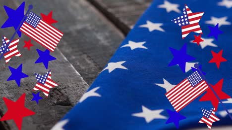 animation of stars and stripes over american flag lying on wooden table