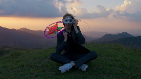 slow motion shot of a woman sitting holding a mask and props as a halloween outfit