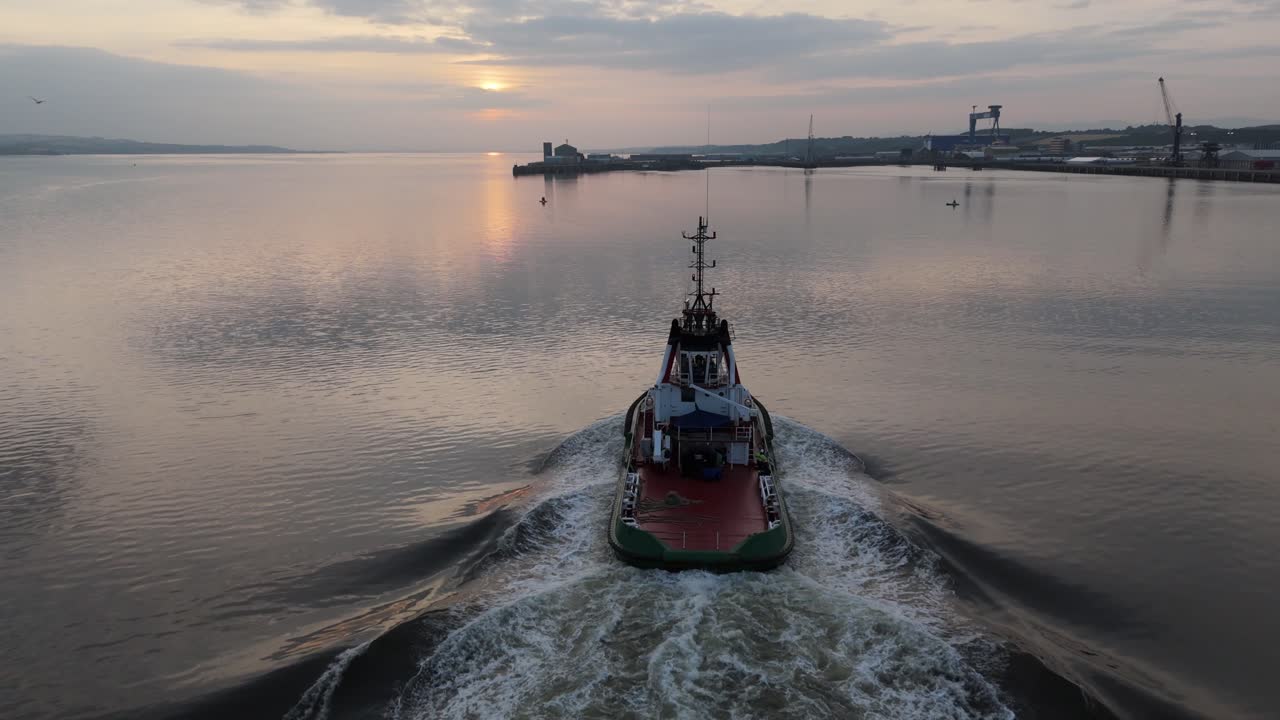 vista aérea de un barco que va a atracar durante una puesta de sol en el mar del norte de escocia