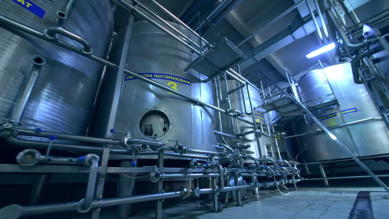 Big room in the milk manufacturing factory. Stainless steel modern equipment for dairy production. View from below.