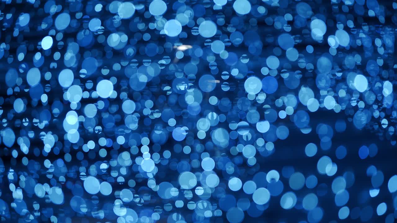 추상적인 배경은 크리스마스 보케 공을 가지고 있습니다. 새해 휴일 배경은 전구 장미의 반이는 불빛과 함께. 밤에는 밝은 겨울 파티 불빛의 실제 렌즈 흐릿함.