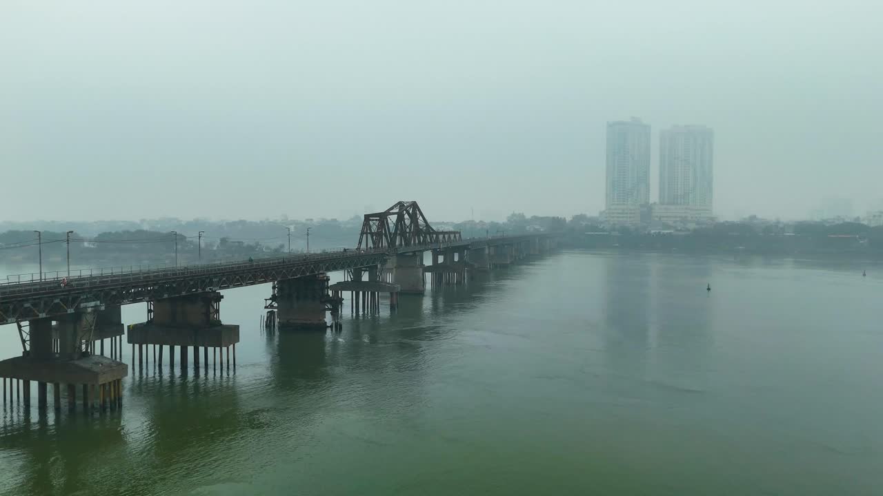 Aerial: Long Bien Bridge with fog and extreme pollution during the day in Hanoi, the capital city of Vietnam, push in drone shot