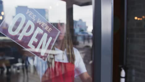 Barista-Gemischter-Abstammung-Mit-Dreadlocks,-Der-Die-Tür-Schließt-Und-Das-Schild-Von-„offen“-Auf-„geschlossen“-Umstellt