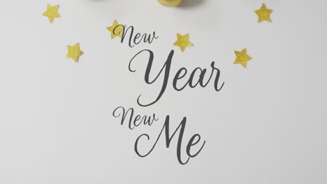 animation of new year new me text over christmas decorations