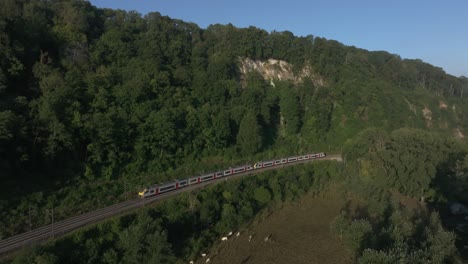 Aerial-view-of-a-Belgium-train-cruising-through-nature-at-daytime