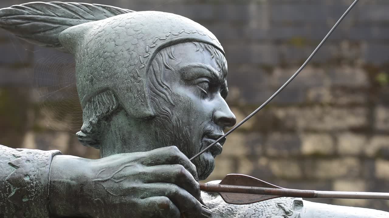 The Robin Hood statue stands proudly on Castle Road in Nottingham, England, aiming his arrow toward the historic gatehouse of Nottingham Castle