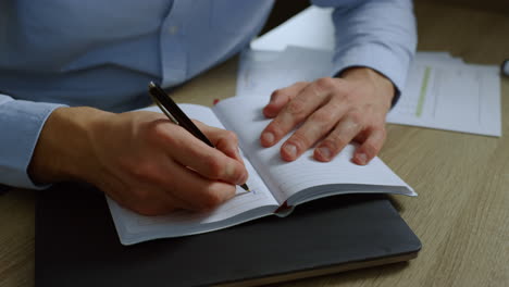 Manos-De-Hombre-De-Negocios-Tomando-Notas-En-El-Cuaderno.-Horario-De-Escritura-Ejecutiva-En-El-Diario