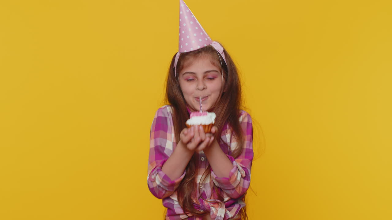 niño feliz niña niño celebrando fiesta de cumpleaños, hace un deseo soplando vela encendida en un pastelito pequeño