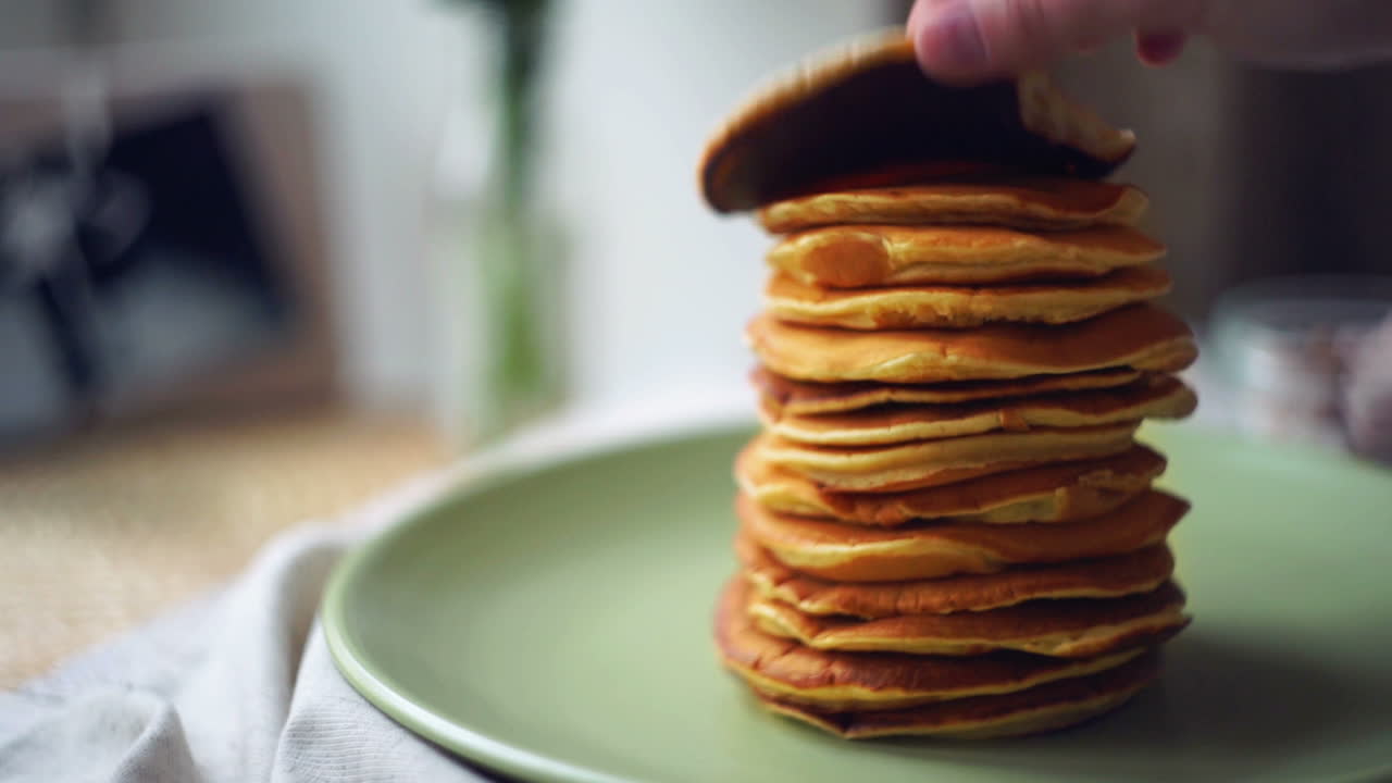 hombre tomar un panqueque de la pila de panqueques. comida de postre para el desayuno de la mañana