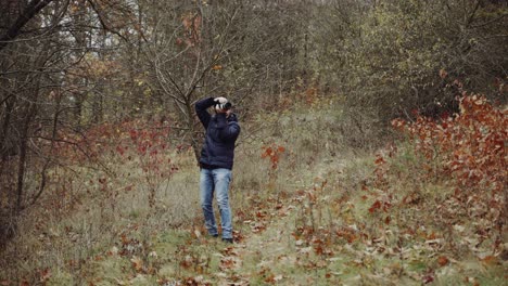 man standing on shore. aerial view of man standing on lake shore and taking photo of nature