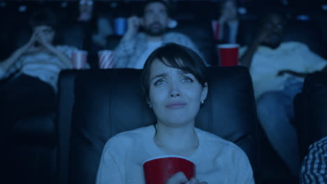 woman reacts to a scary movie in the theater