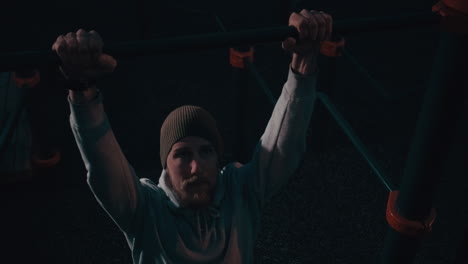 man performing pull-ups at night