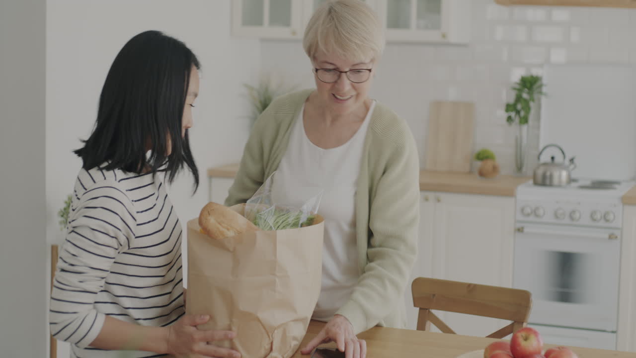 Daughter Helping Elderly Mother with Groceries