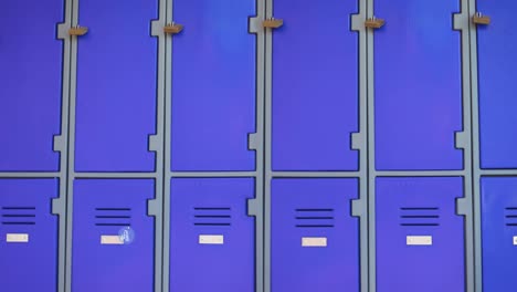 animation of text welcome back to school and paper plane in blue circle moving over blue lockers