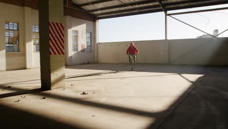 jinete de bmx en un almacén vacío