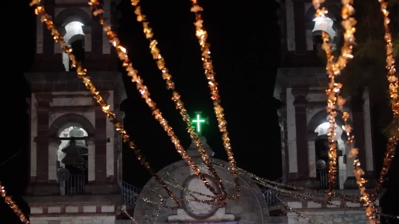 A catholic church bell towers decorated with bright and colorful decoration during a catholic festivity in mexico
