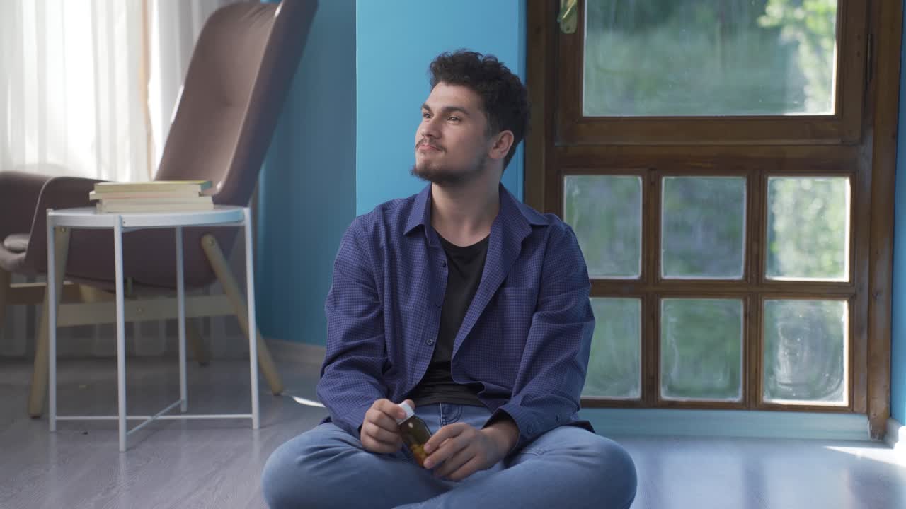 un hombre suicida apoyado en la pared.