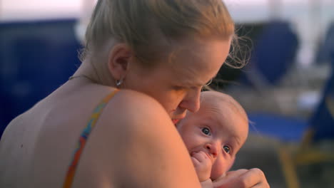 Loving-mother-kissing-and-embracing-baby-daughter