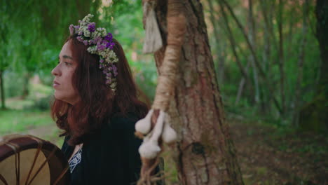 druid-girl-in-a-forest-playing-a-shamanic-drum-side-view-close-shot