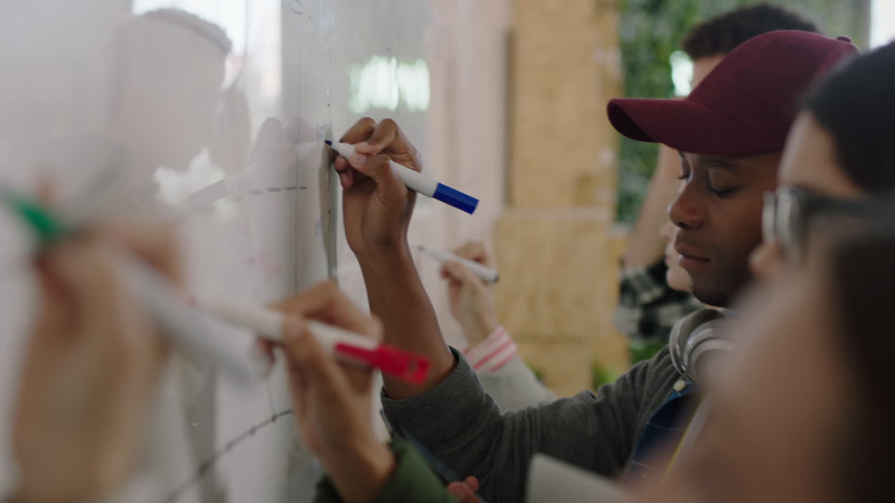 equipo de negocios diverso lluvia de ideas escribiendo ideas creativas en pizarra colaborando en un proyecto de datos de investigación de mercado compartiendo información en una reunión de oficina multiétnica