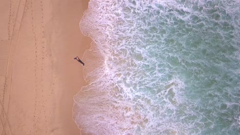 Top-Vogelperspektive-Eines-Mannes,-Der-Am-Strand-Spaziert