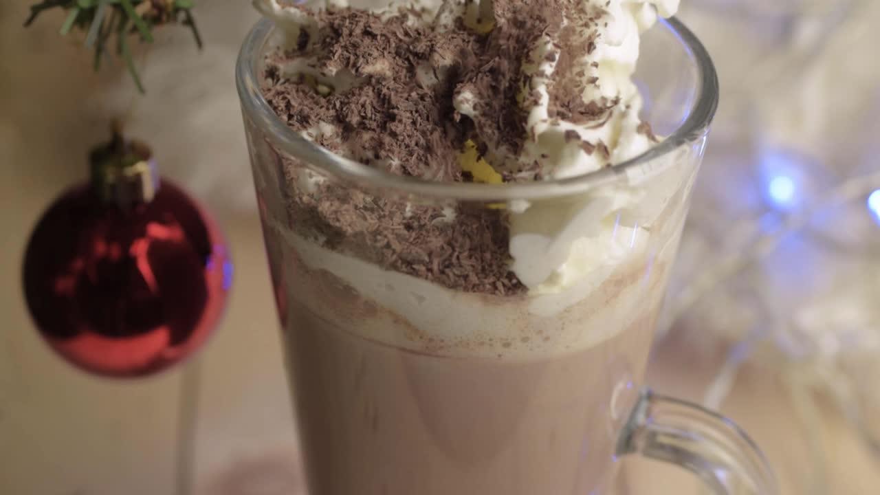 크리스마스에 핫 초콜릿 음료에 휘핑 크림 토핑 위에 초콜릿을 뿌리는 것