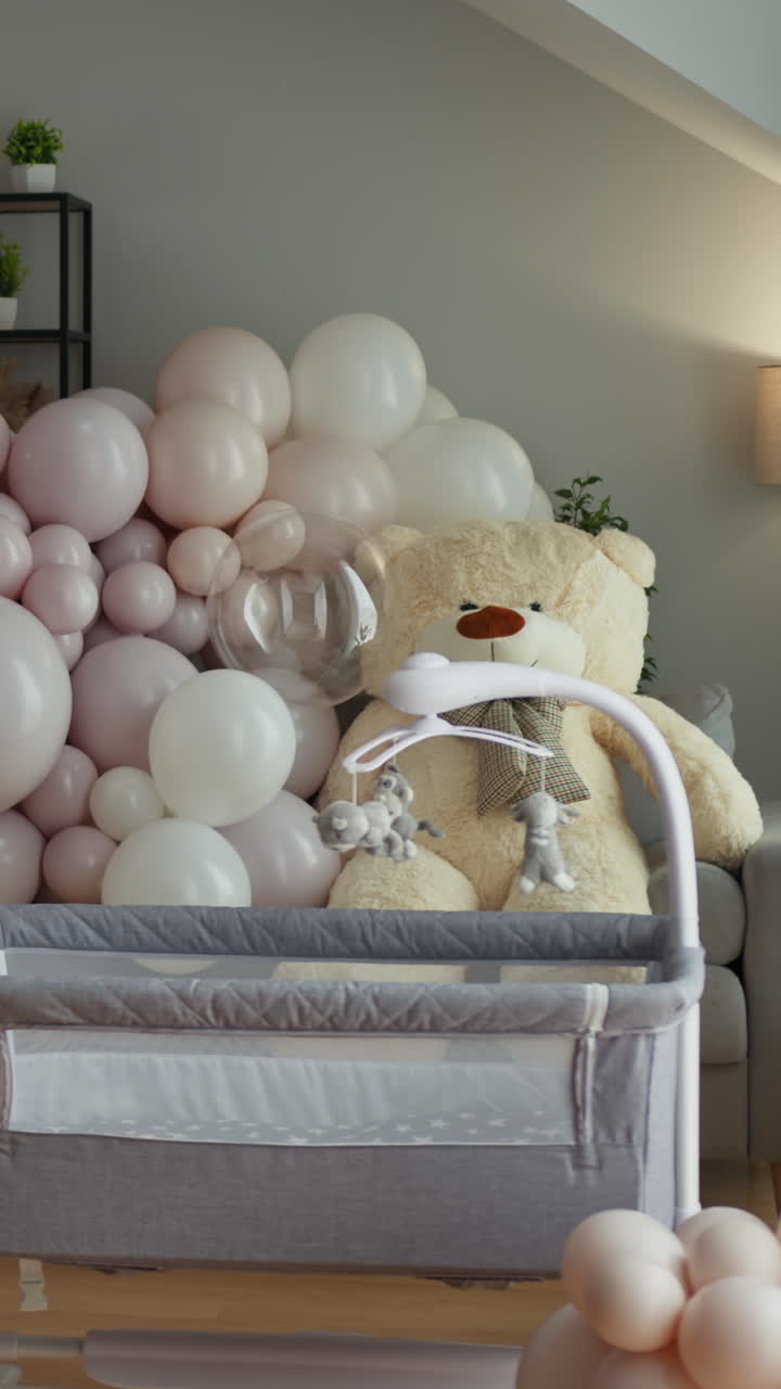 Una culla per neonati decorata con palloncini e un orsetto di peluche che crea un'atmosfera festosa per un bambino