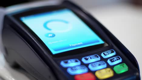 close-up of a modern payment terminal displaying a transaction progress indicator and payment confirmation screen for seamless digital transactions