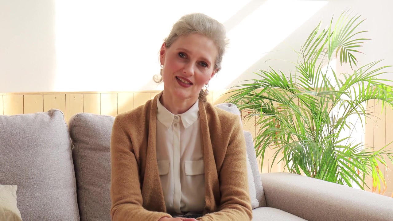 Mature Woman Talking and Gesturing During Video Call on Sofa