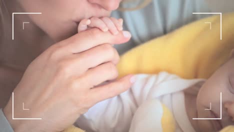 animation of frame over caucasian mother kissing hand of her baby