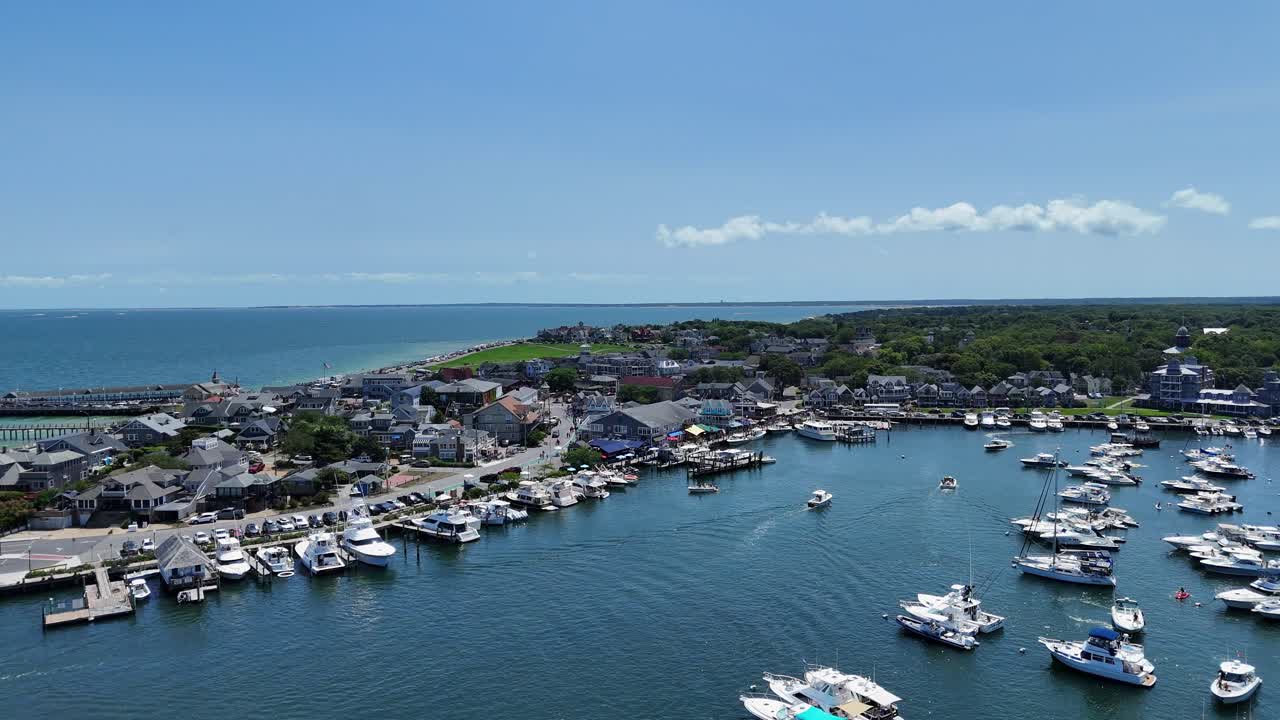 Volo in avanti del drone verso l'area del molo dei traghetti di Oak Bluffs Harbor con navi ormeggiate e la regione della città di Oak Bluffs, Martha's Vineyard, Massachusetts, USA