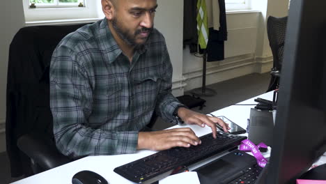 Close-up-shot-of-a-man-typing-on-his-desktop-pc-on-computer-table-in-office-at-daytime