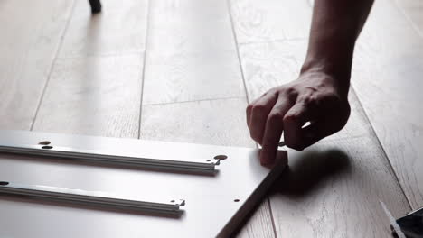 diy fail, man takes out crooked screw from wooden shelf part