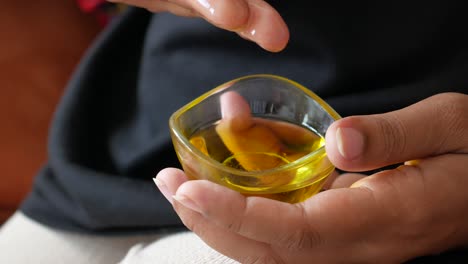 mujer aplicando aceite amarillo a su piel