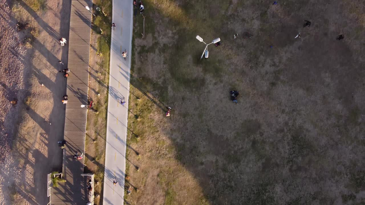 일몰 동안 비센테 로페즈의 해안 공원 지역을 따라 자전거를 타는 자전거 타는 사람의 공중 하향식 사진 - 부에노스 아이레스, 아르헨티나