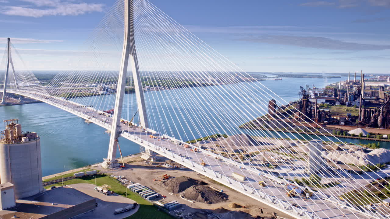 Dramatic cinematic drone shot sweeping around the international bridge joining the U.S. and Canada