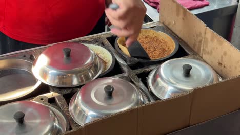 a close-up of a vendor making peanut pancakes, aka apam balik, min jiang kueh or tai kau min on a hawker street food stall in penang, malaysia
