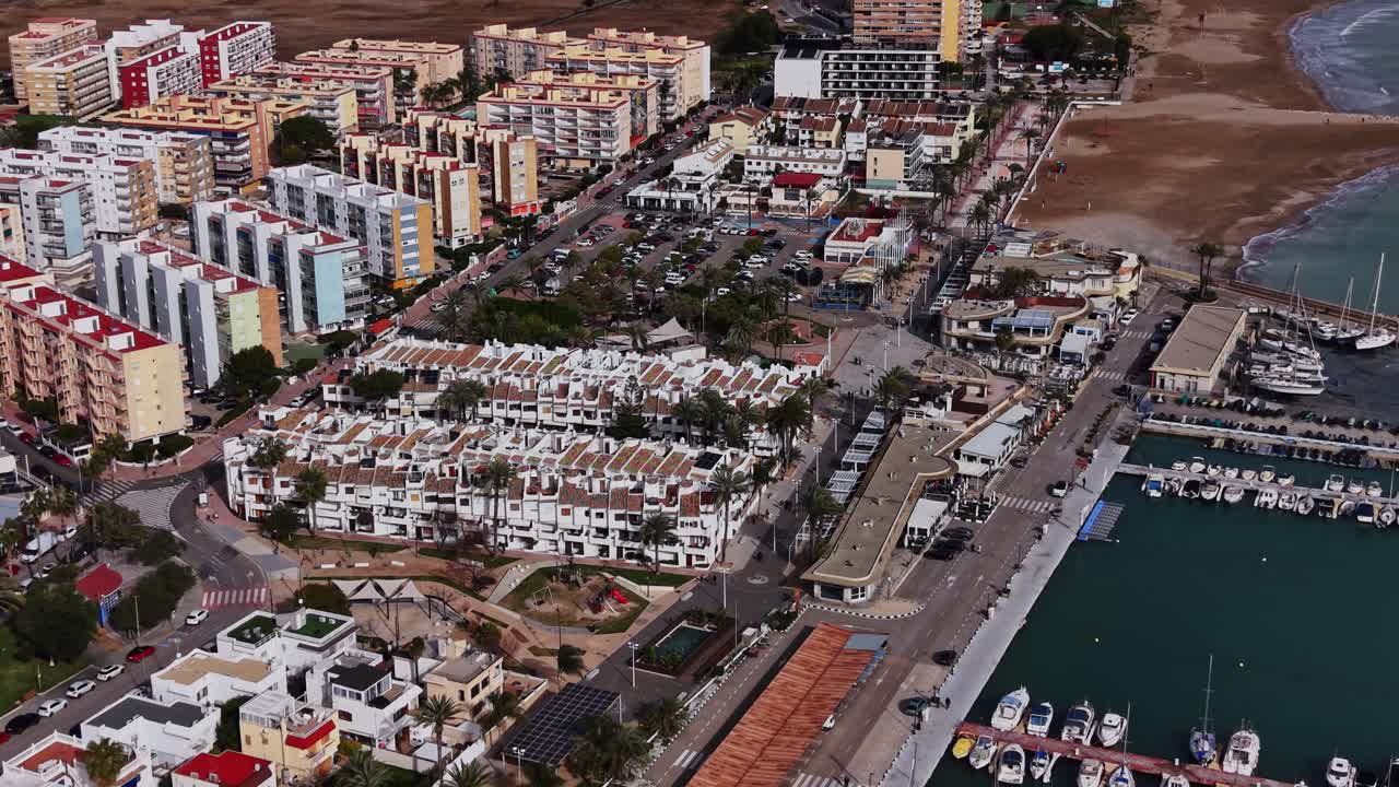 Vista di una città costiera in Spagna con edifici, strade e barche