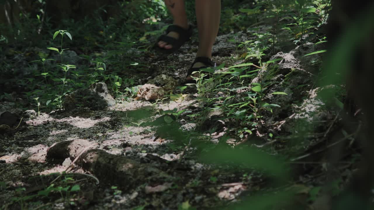 Close up shot of a woman's feet walking along a rocky road