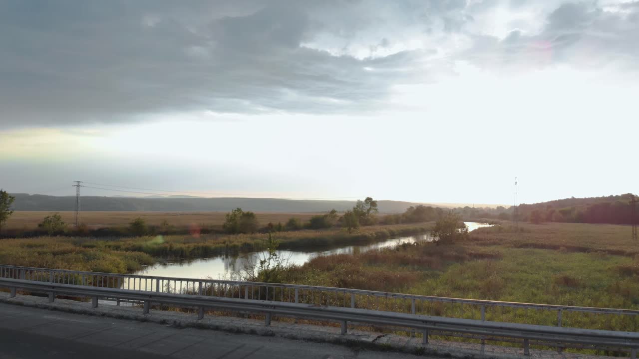 강 위의 다리에서 자동차 운전 - 낮은 공중 촬영
