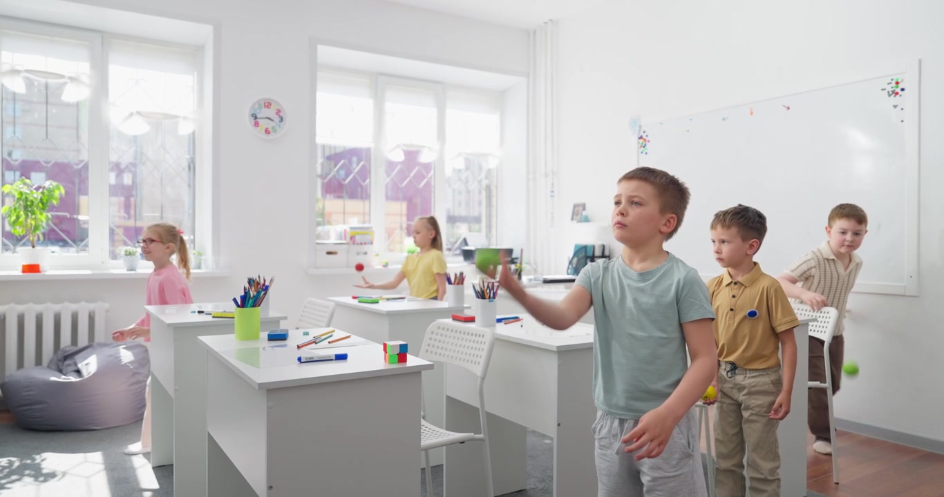Sekelompok Anak-anak Bermain Juggling Bola Kecil di Ruang Kelas Modern