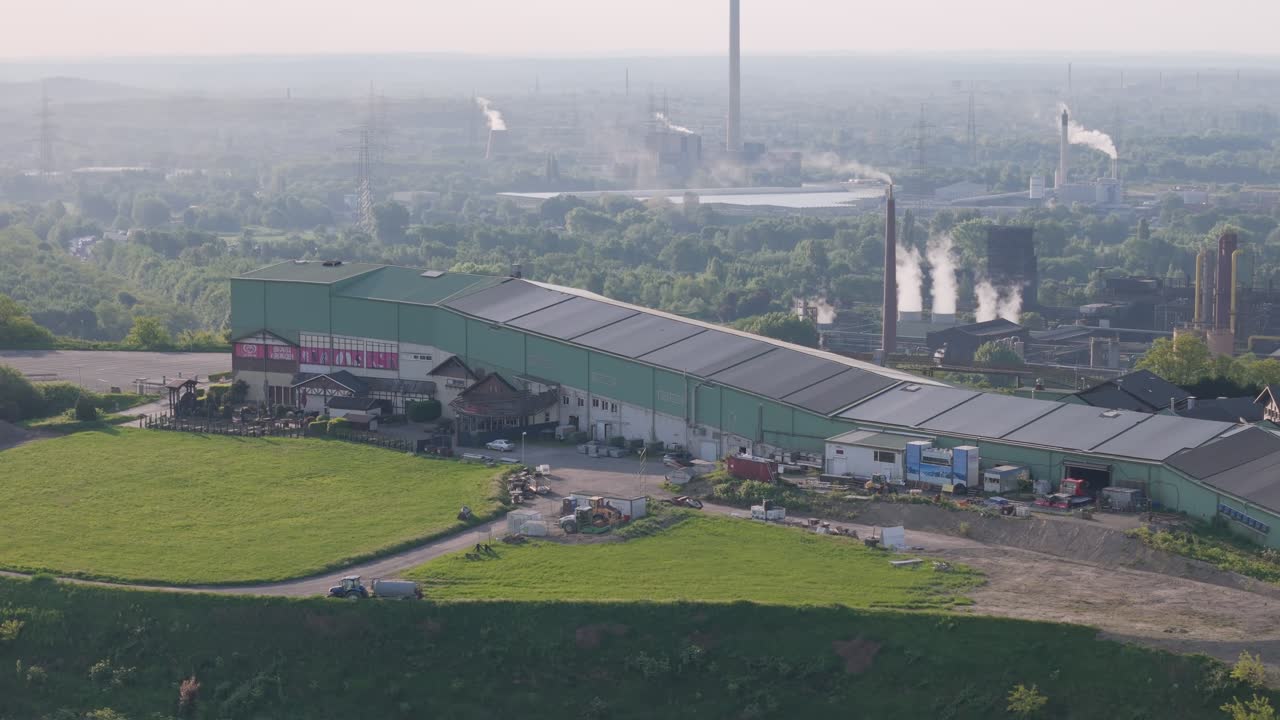 Prosper coking plant with steam plume emerging from quenching tower in background, Alpincenter Bottrop ski resort in foreground, North Rhine-Westphalia, Ruhr Area, Drone shot
